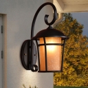 Amber Glass Cylinder Wall Lamp Rustic Outdoor Wall Mounted Light in Black with Metal Cage